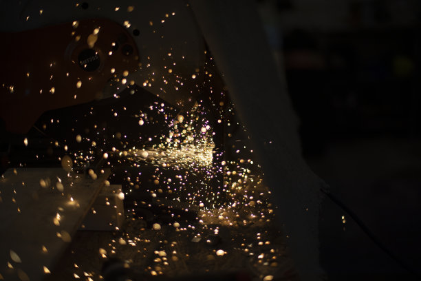 灯光向四面八方飞来。电锯的火花。黑暗中的灯光。图片下载