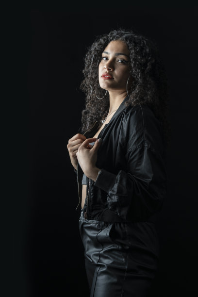 一个年轻的哥伦比亚妇女的肖像在工作室与黑色背景图片下载