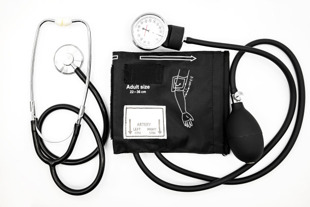 白色背景特写上的黑色血压计和听诊器图片下载