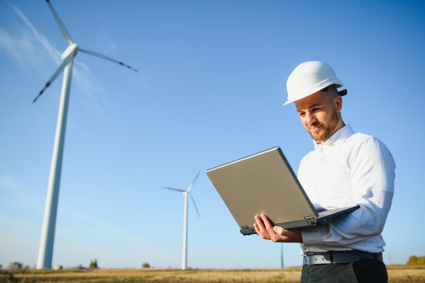 年轻的工程师在现场检查风力涡轮机图片下载