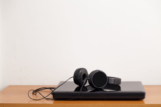 笔记本放在桌上，还有有线耳机。图片下载