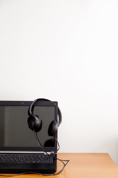 笔记本放在桌上，还有有线耳机。图片下载