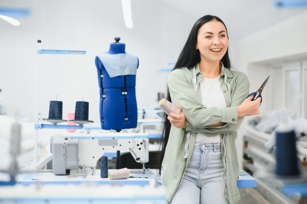 快乐的女裁缝在纺织厂缝纫机工作。图片下载