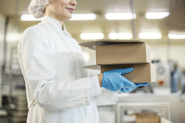 食品厂工人在工厂搬运箱子的特写。图片下载