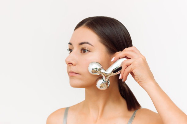 一位年轻女子正在给自己做面部按摩图片下载