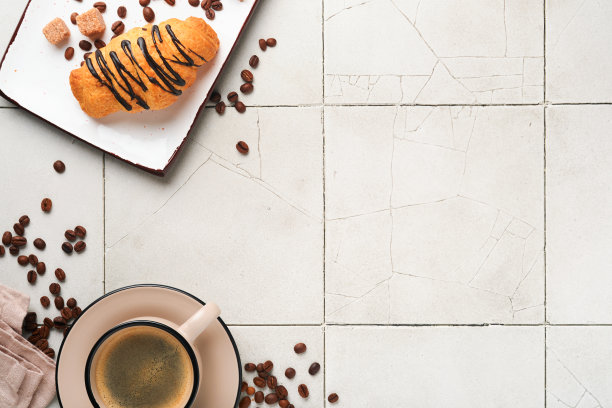 咖啡和羊角面包。有裂纹的旧瓷砖桌上放着浓缩咖啡和巧克力羊角面包。完美的羊角面包早餐。乡村风格。前视图。模拟。图片下载