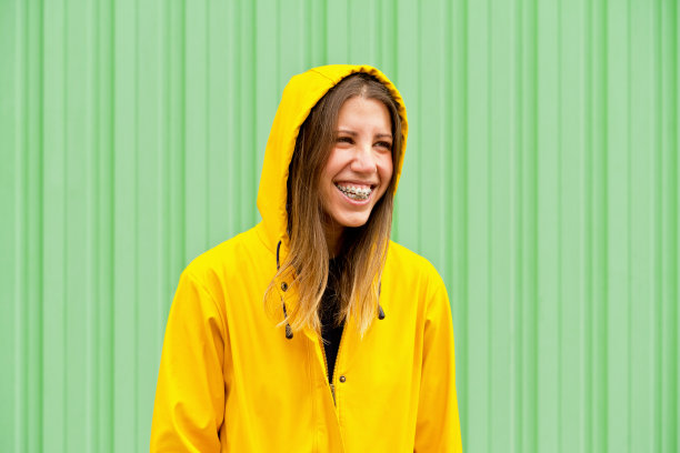 穿着雨衣的快乐女人的中角肖像。图片下载