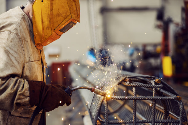 一名重工业工人在工厂里使用焊机进行金属施工。图片下载