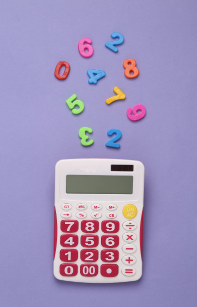 计算器和紫色背景上的许多彩色塑料数字图片下载