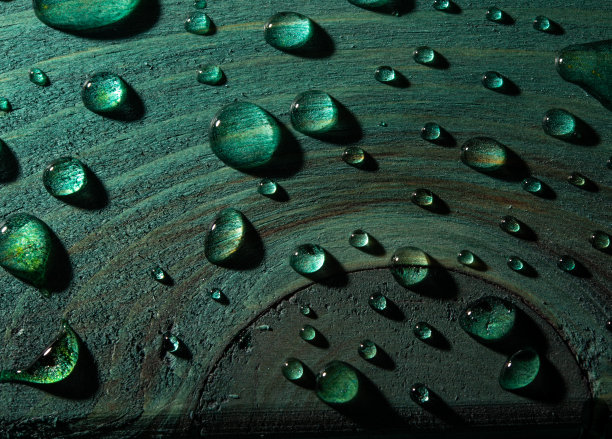 新鲜的雨水水滴在绿色的木桌特写视图图片下载