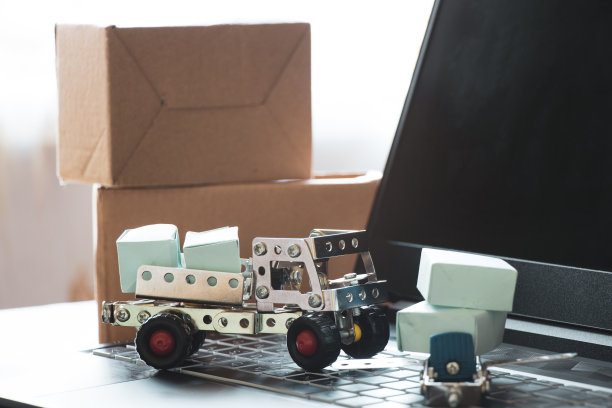 运输、配送与物流概念：笔记本电脑上的卡车、飞机与纸箱图片下载