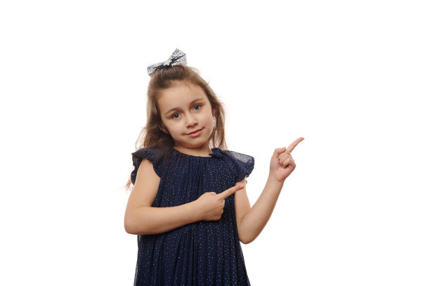 可爱可爱的小女孩，5-6岁，用食指指着你的白色背景广告的复制空间图片下载