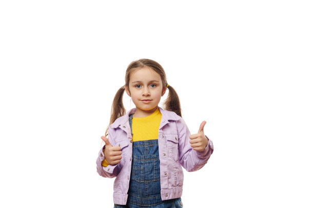 孤立的肖像在白色背景的一个白人迷人的小女孩显示大拇指，看着相机。广告空间图片下载