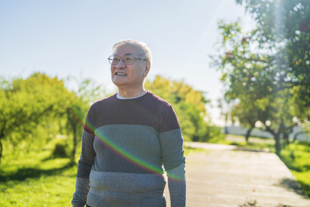 成熟的亚裔美国人在公园散步时花宝贵的时间图片下载