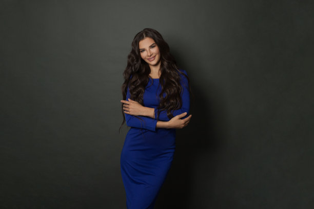 身穿蓝色长袍的长发女性高兴地看着镜头图片下载