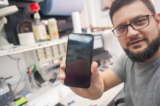 修理工修理，清洁，测试智能手机在电子维修店图片下载