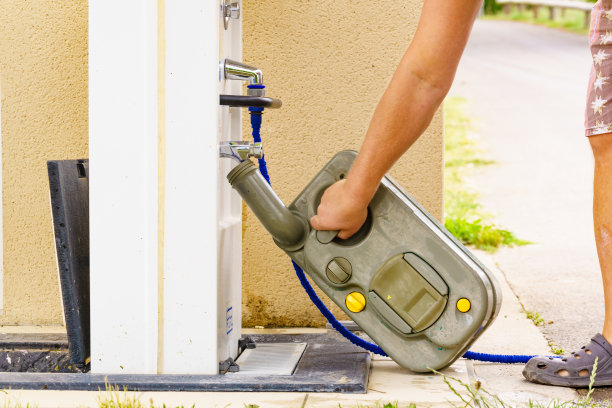 男子在倾倒站清空大篷车水箱厕所磁带。图片下载