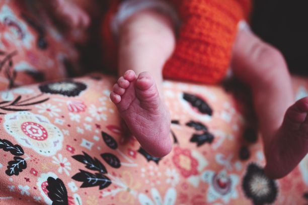在模糊的背景下，一个可爱的婴儿的脚特写图片下载