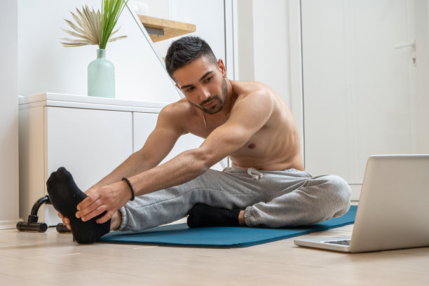 中等体型的年轻人，一边在家观看在线健身课程，一边在健身垫上练习，一边努力锻炼肌肉、减掉腹部脂肪和特定部位的体重。图片下载