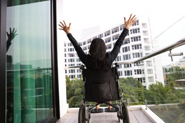 坐在轮椅上的残疾人士在酒店阳台上放松图片下载