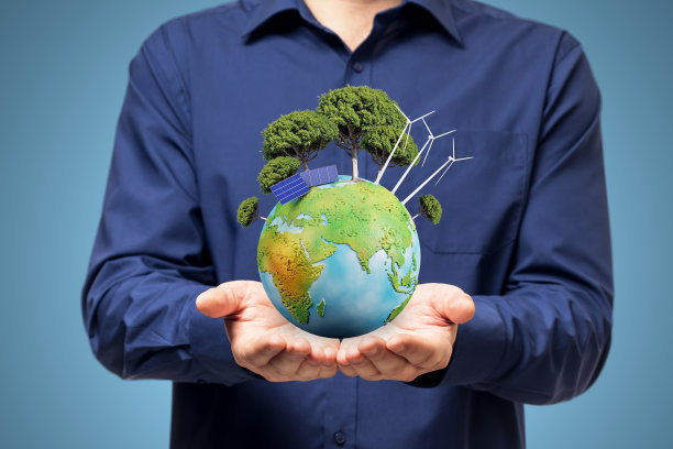 男性的手的特写与树和蓝色背景上的太阳能电池板创造性的地球。能源与可持续发展理念。图片下载