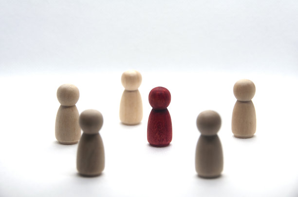 木制红色人物周围的其他人物在白色背景。图片下载