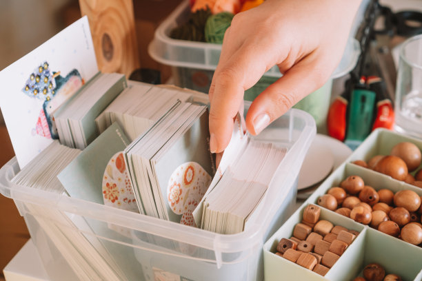 裁剪的照片的女人的手准备和选择模式卡的透明盒送货包木珠图片下载