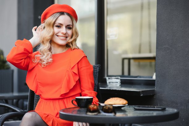 非常漂亮的年轻女子，坐在咖啡馆喝咖啡或茶，街景图片下载