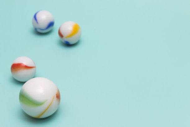 水蓝色背景上的玩具弹珠图片下载