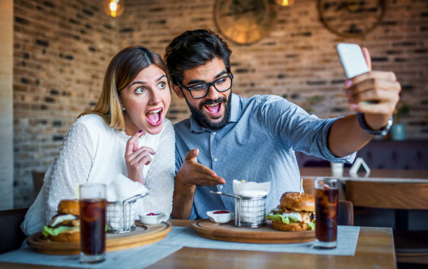 一对年轻夫妇坐在咖啡馆里吃早餐。爱情，约会，食物，生活方式的概念图片下载
