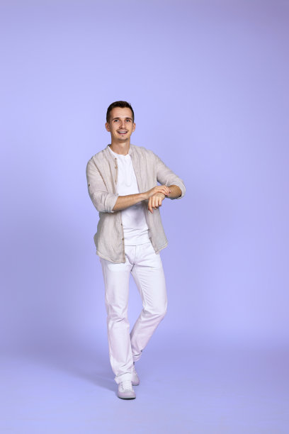 穿着休闲衬衫的男子在紫色背景上摆姿势。图片下载