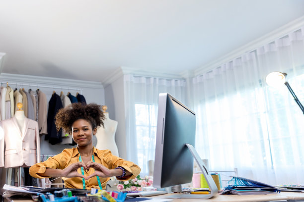 女时装设计师在裁缝店工作。时装设计人体模型测量概念图片下载