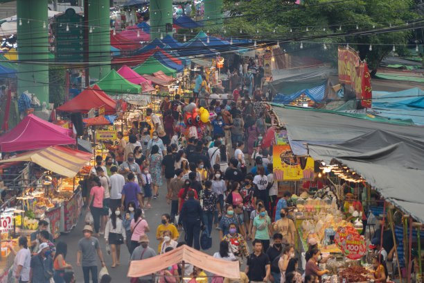 夜市的人们走在街市上，五颜六色的帐篷在Ratchada火车在曼谷市，泰国。Rerail商店图片下载
