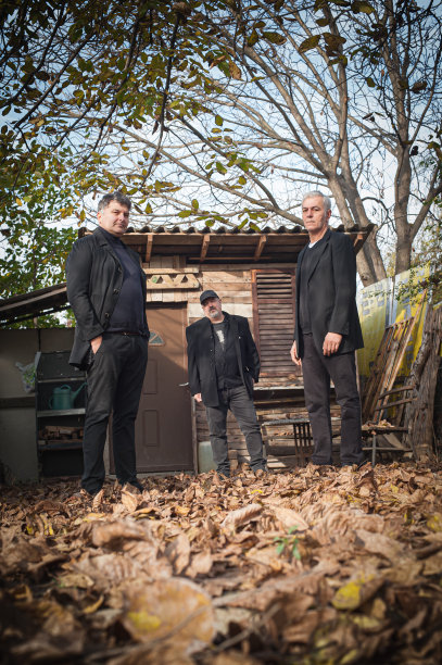 三个时尚的艺术家在户外穿着黑色优雅的西装图片下载