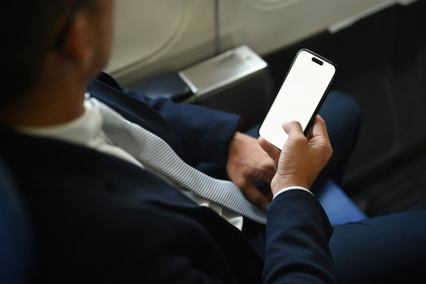 商人检查工作，智能手机上的新闻，在飞机上使用无线连接。图片下载