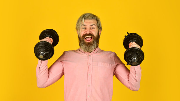 一天比一天强大。运动的生活方式。运动动机。帅哥健身。在健身房锻炼。肌肉男用哑铃锻炼。运动员训练强壮的肌肉。健身健美运动图片下载