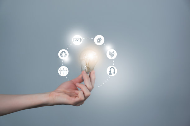 女人的手握着带有能源图标的发光灯泡。生态友好和可持续的环境理念。图片下载