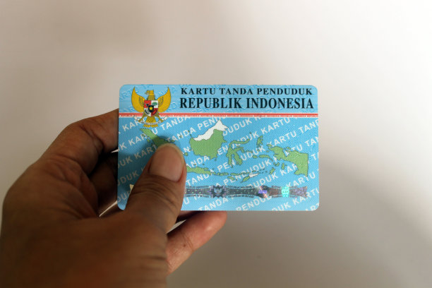 近距离照片，人手拿着小钱包和印尼公民身份证。图片下载