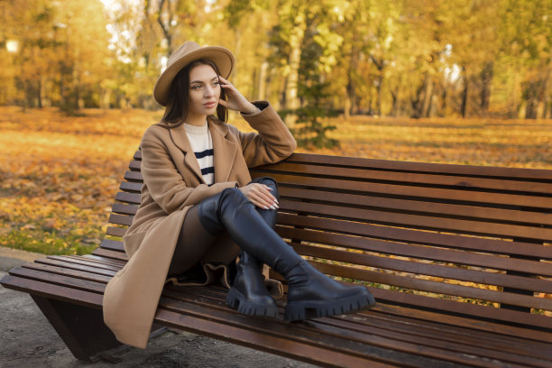 疲惫或沮丧的年轻女子抚摸她的头在秋天的公园。这个女孩头痛得厉害，感到孤独、压力大或不开心，有问题图片下载