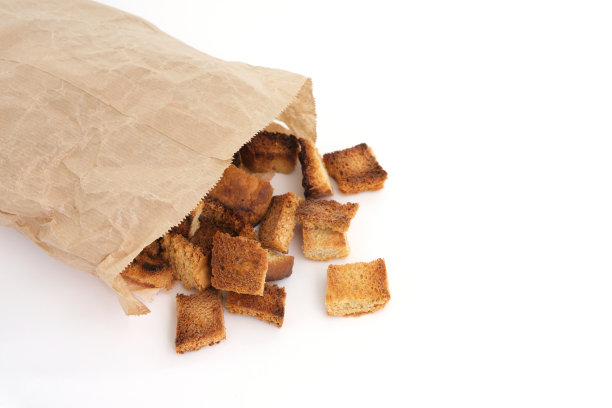 油炸面包屑装在纸袋里，白色背景。自制的食物。图片下载