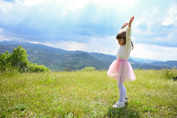 户外徒步旅行家庭度假。从后面的一个小女孩在山上看风景。图片下载