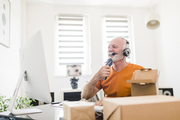 微笑的资深男性社交媒体技术影响力与耳机录制开箱视频在家里图片下载