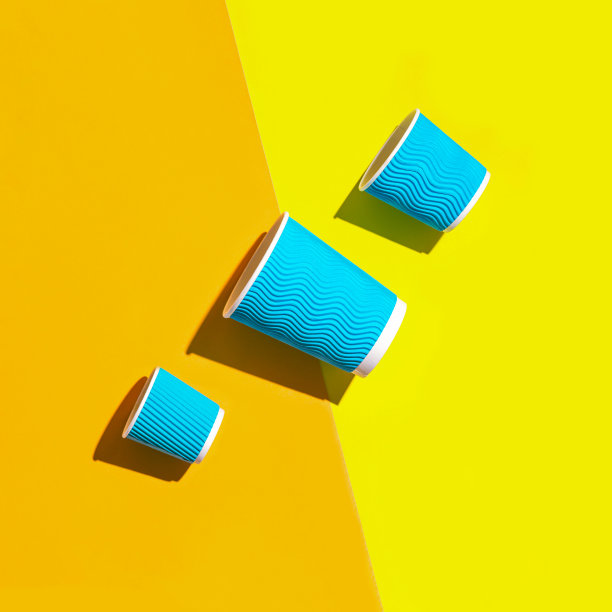 蓝色纸杯咖啡或茶的创意布局，以亮橙色和黄色为背景。环保理念。平的。俯视图图片下载