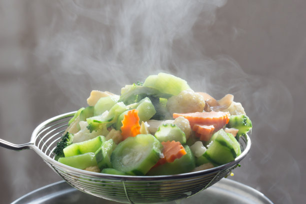 黑暗中蔬菜滤锅里冒出的蒸汽图片下载