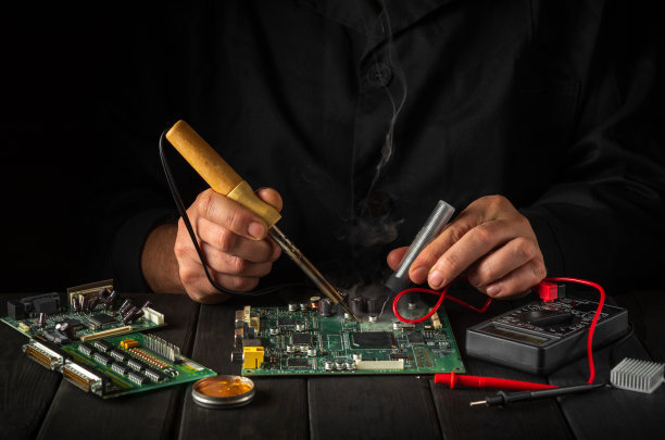 工头在车间里修理电脑或电子设备。由车间专家提供的电脑维修服务图片下载