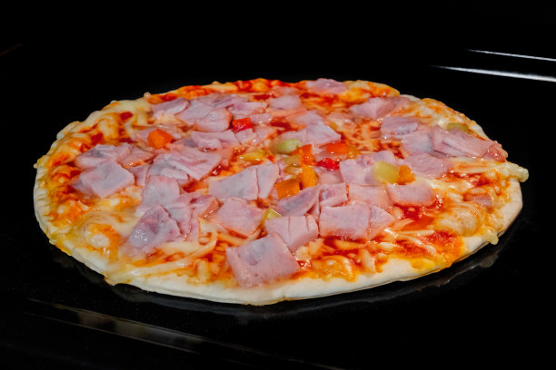 未煮熟的自制披萨，放在电烤箱托盘上图片下载