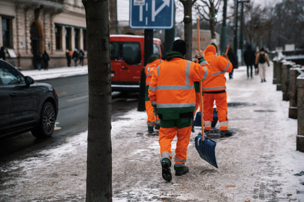 三个清洁工正在清扫城市街道上的积雪图片下载