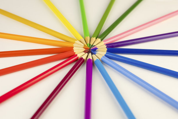 彩色铅笔放在白色桌子上的玻璃杯里。图片下载