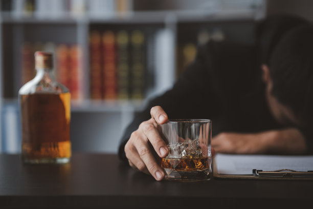 一个律师拿着一杯威士忌，他在他的办公室里，他在为一个客户辩护，他是个律师。法律诉讼概念明确。图片下载