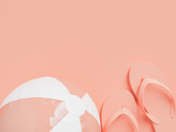 粉色表面的人字拖和充气沙滩球图片下载